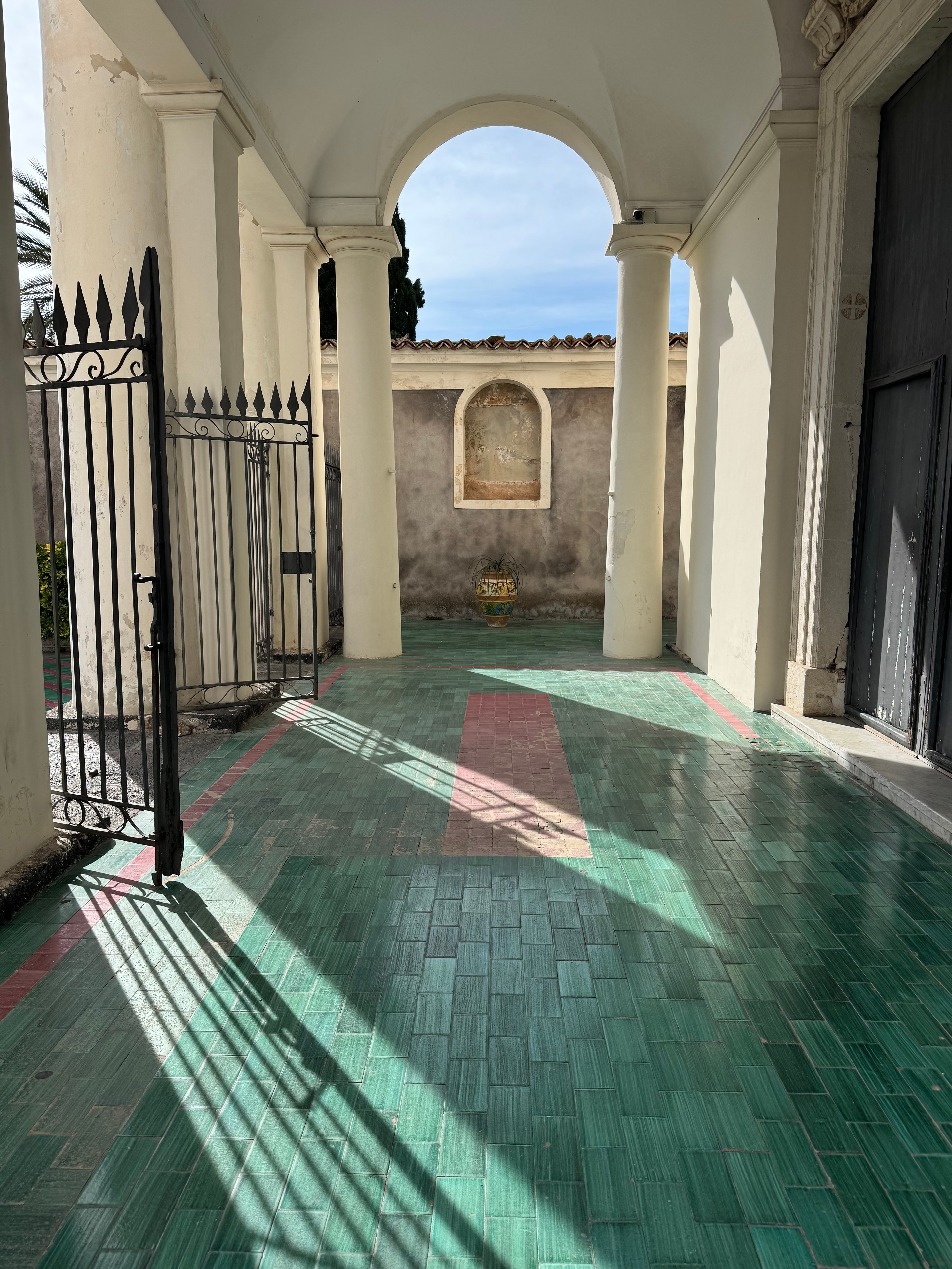 Sunlit courtyard with green and pink tiled flooring