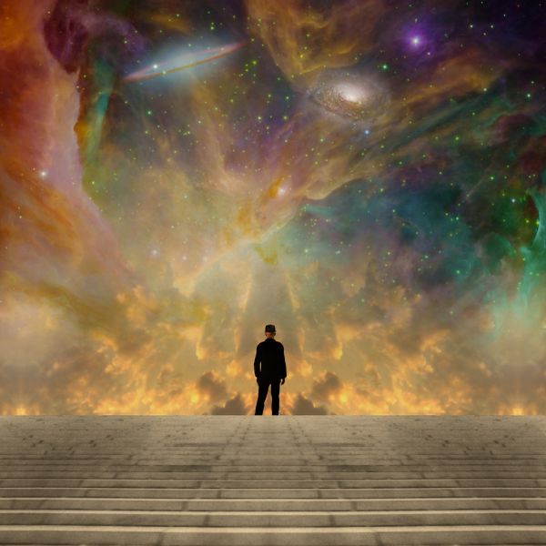 Person standing before a vast colorful cosmic scene.